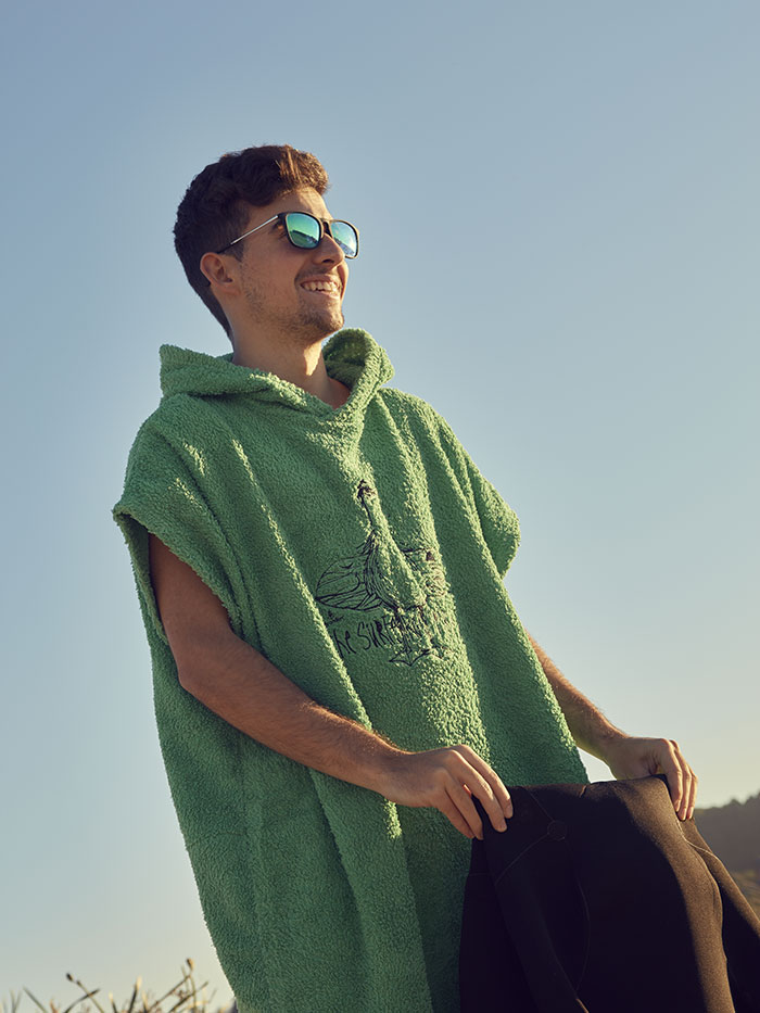 poncho de toalla para surf surfista cambiandose con un poncho